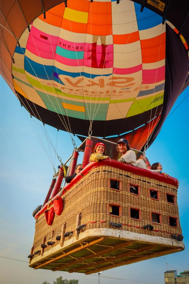 Travelers in a balloon basket above the clouds