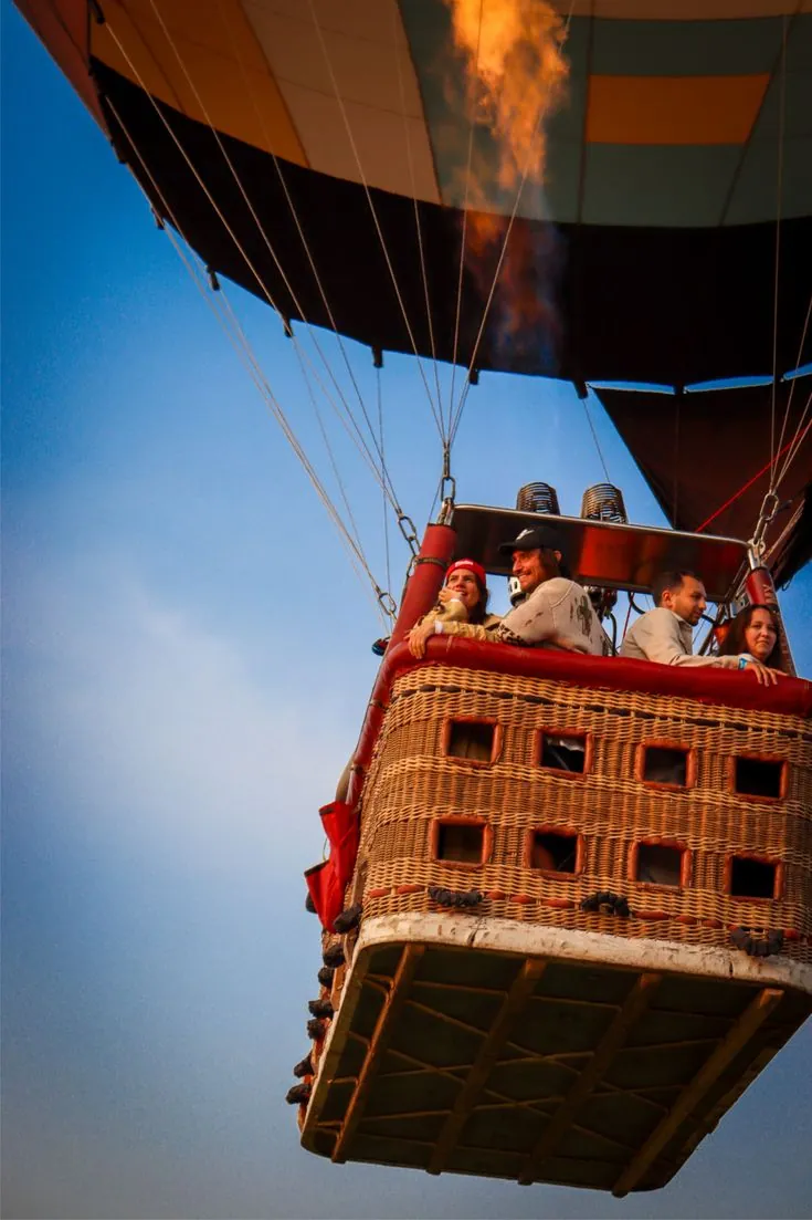 Travelers smiling during a sunrise balloon flight
