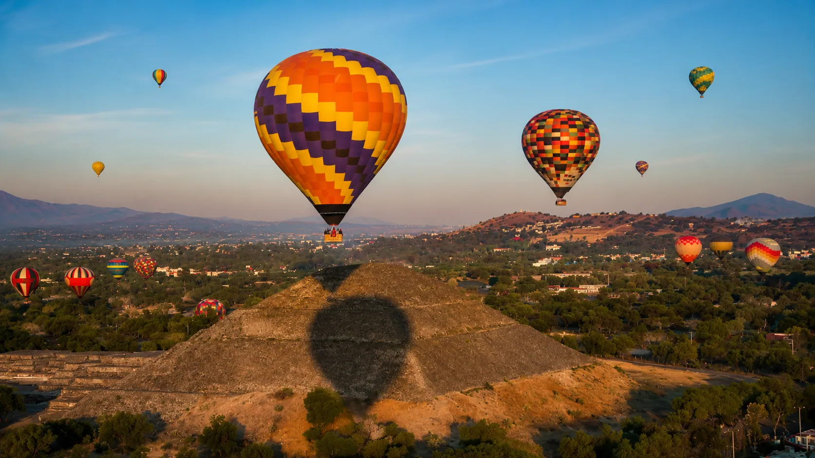 Hot air balloons spread across the Teotihuacán valley in the early morning